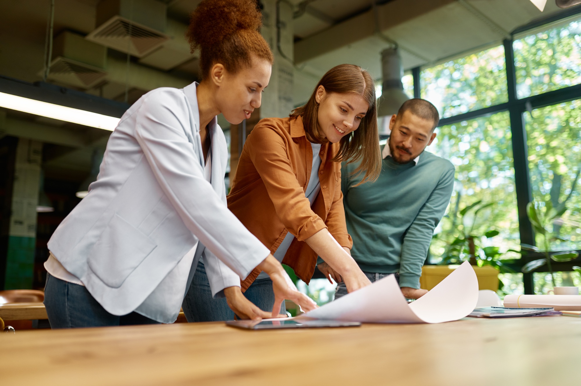 Group of designers multiethnic team discussing affairs at coworking office